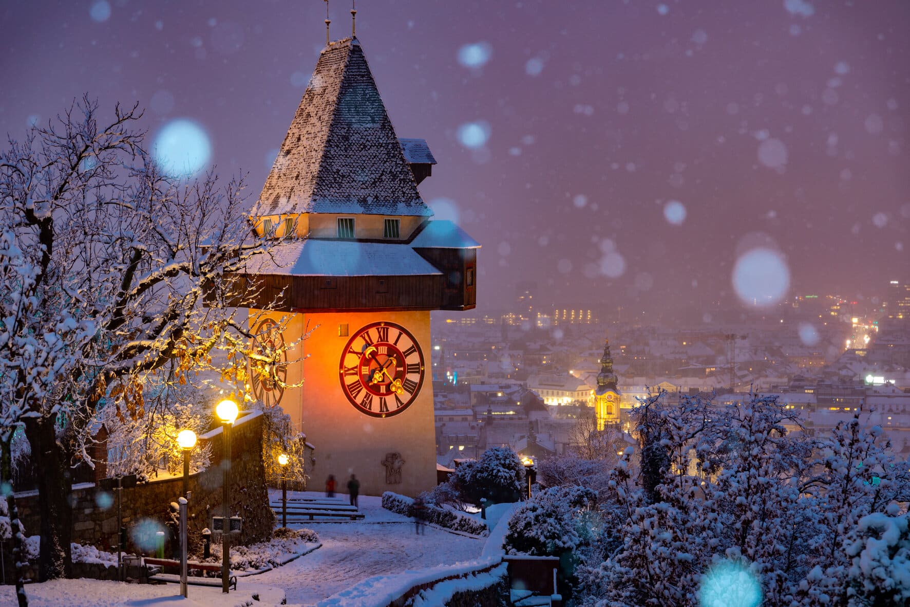 Grazer Uhrturm in einer Schneelandschaft rund um den Grazer Advent